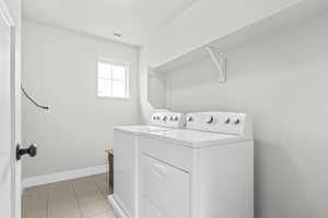 Clothes washing area featuring washer and dryer and baseboards