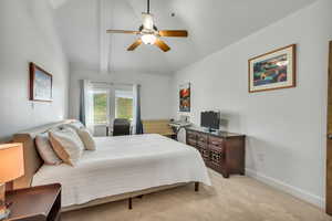 Bedroom 10' x 17' with Mountain Views featuring light colored carpet, a ceiling fan, 8'x7' Walk-In Closet and vaulted ceilings.