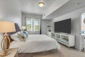 Bedroom featuring new carpet and large walk in closet.