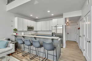 Updated Kitchen with All New Samsung Stainless appliances with stainless steel finishes, a peninsula, recessed lighting, a breakfast bar, and LVP Whisper Core Flooring.