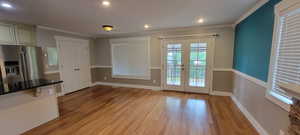 Doorway to outside with french doors, light wood-style flooring, baseboards, crown molding, and recessed lighting