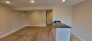 Spare room featuring recessed lighting, a sink, baseboards, and light carpet