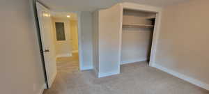 Unfurnished bedroom featuring carpet, electric panel, a closet, baseboards, and recessed lighting