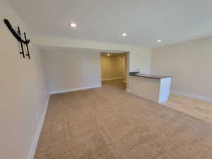 Unfurnished room featuring recessed lighting, light carpet, baseboards, and a textured ceiling