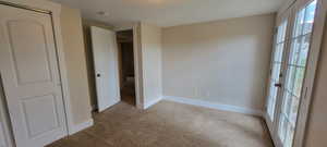 Unfurnished bedroom with carpet floors and baseboards