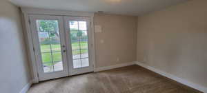 Doorway with french doors, carpet floors, and baseboards