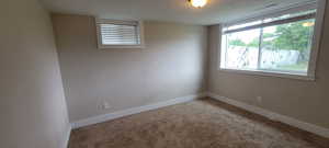 Carpeted spare room with baseboards