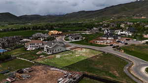 Aerial view of property and surrounding area with a mountainous background and nearby suburban area