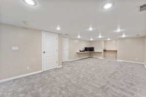 Finished basement featuring carpet floors, baseboards, recessed lighting, and a textured ceiling