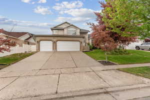 Traditional-style house featuring driveway, stucco siding, an attached garage, and brick siding