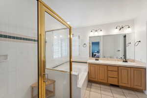 Full bath featuring a stall shower, a bath, tile patterned flooring, and double vanity