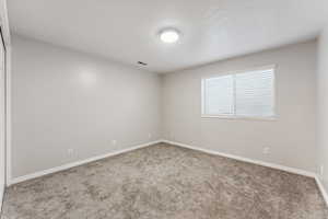 Carpeted spare room featuring baseboards