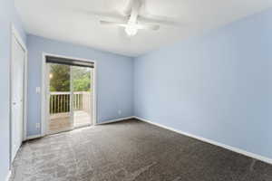 Carpeted spare room featuring a ceiling fan and baseboards