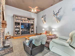 Carpeted living room with a ceiling fan