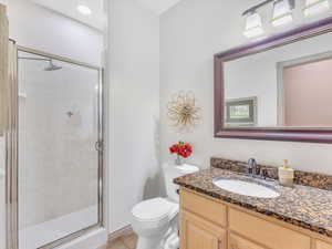 Full bathroom featuring a shower stall, toilet, tile patterned floors, and vanity