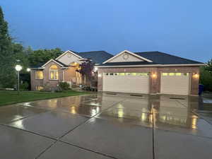 Ranch-style home with concrete driveway, brick siding, a garage, and a yard