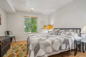 Bedroom with wood finished floors and baseboards