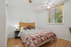 Bedroom featuring wood finished floors, baseboards, and a ceiling fan