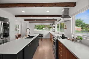 Wood accent beams, ceramic cooktop with pot filler, and vented range hood
