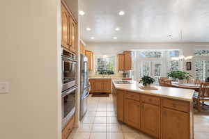 Kitchen featuring appliances with stainless steel finishes, a kitchen island, recessed lighting, healthy amount of natural light, and light countertops