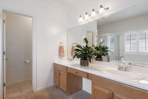 Full bathroom with a stall shower, double vanity, tile patterned floors, and a garden tub