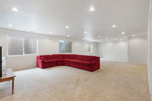 Living area featuring light colored carpet, recessed lighting, and baseboards
