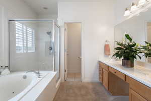 Full bath featuring a shower stall, a bath, and double vanity