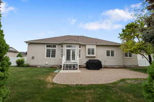 Rear view of house with stucco siding and a patio