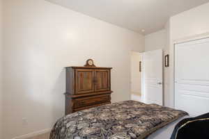Bedroom with carpet flooring, a closet, and baseboards