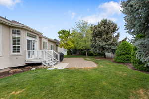 View of green lawn with a patio area