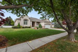 View of front of house featuring stucco siding, concrete driveway, and a garage