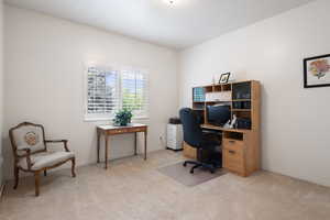 Home office with light carpet and baseboards