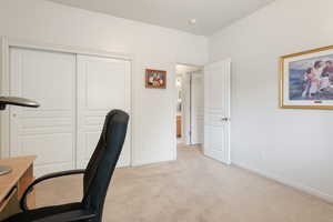 Home office with light carpet and baseboards