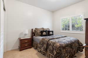 Bedroom with light colored carpet and baseboards