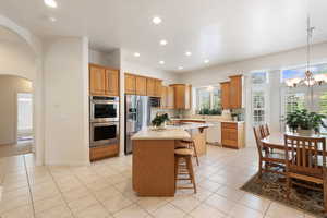 Kitchen featuring appliances with stainless steel finishes, a kitchen breakfast bar, light countertops, a kitchen island, and recessed lighting