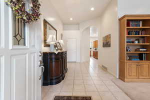 Entrance foyer featuring arched walkways, light tile patterned floors, recessed lighting, and baseboards