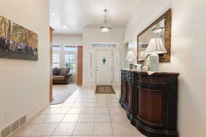 Entryway with light tile patterned floors, baseboards, and recessed lighting