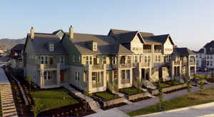 View of front of property featuring a residential view, a chimney, and a balcony