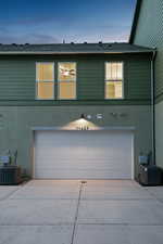 View of front of house with a garage, central AC, and driveway