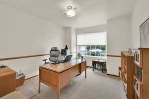 Office with light colored carpet and baseboards