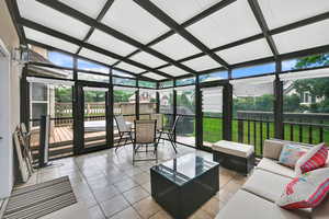 Sunroom / solarium with an outdoor living space, plenty of natural light, lofted ceiling, and outdoor dining space