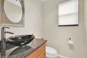Bathroom with vanity, toilet, and baseboards