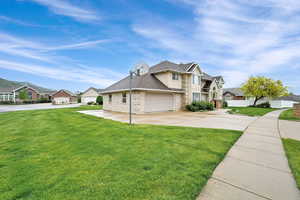 Traditional-style house featuring a residential view, driveway, stone siding, and a garage