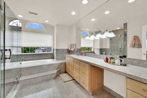 Bathroom featuring healthy amount of natural light, vanity, a shower stall, a garden tub, and recessed lighting