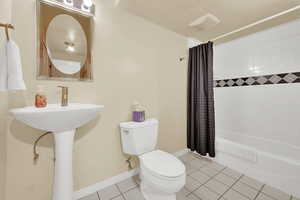Full bathroom featuring toilet, tile patterned floors, and shower / bath combo