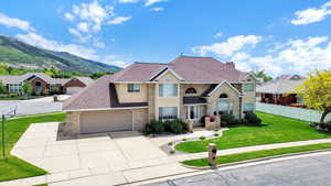 Traditional-style home with driveway, a mountain view, an attached garage, and stone siding