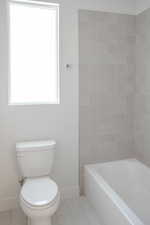 Bathroom with baseboards, tile patterned flooring, and toilet