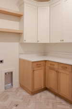 Laundry area with cabinet space and hookup for an electric dryer