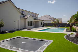 Rear view of property with a tile roof, stucco siding, and a patio area