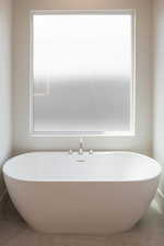 Full bath with a freestanding tub and tile patterned floors